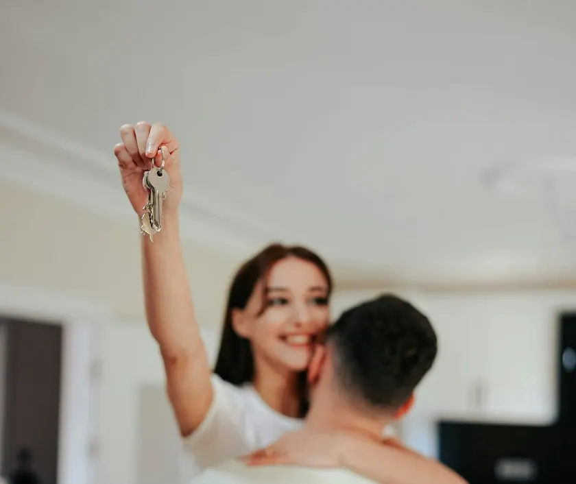 A happy couple holding up the keys to their new home