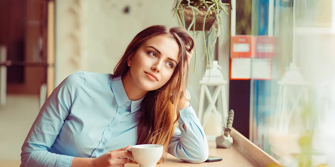 A woman relaxing at home with a cup of coffee