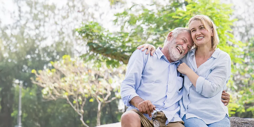 A happy older couple sitting together outdoors