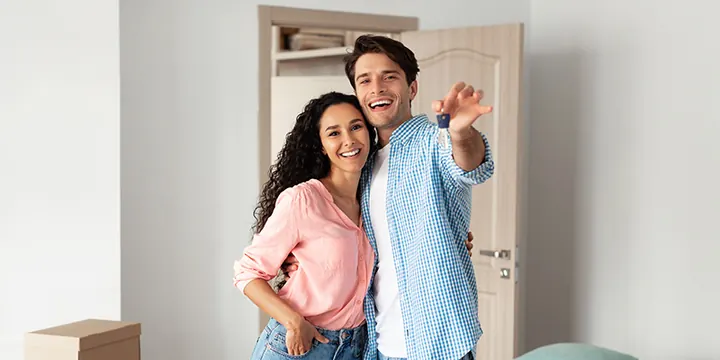 A couple celebrating in their new home among moving boxes