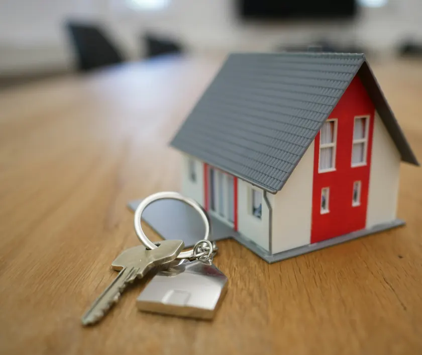 House keys beside a small model house on a table
