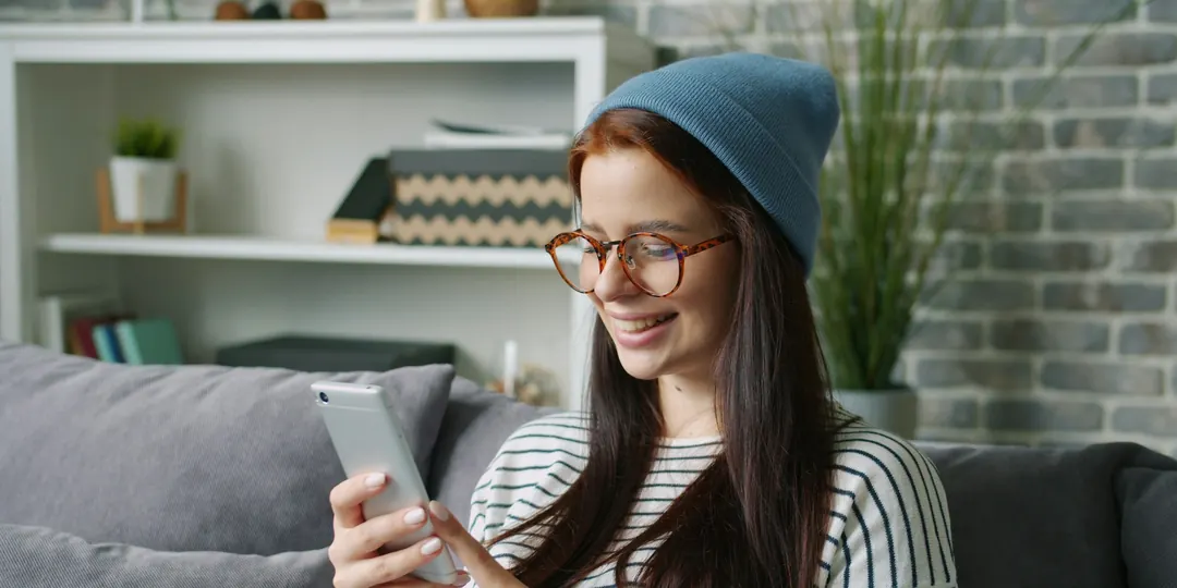 A woman checking her finances on her phone at home