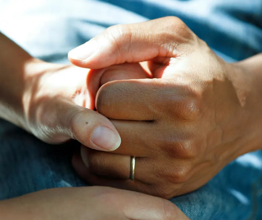 Two people holding hands in support