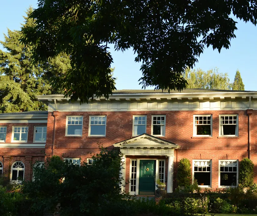 A red-brick family house with a green front door