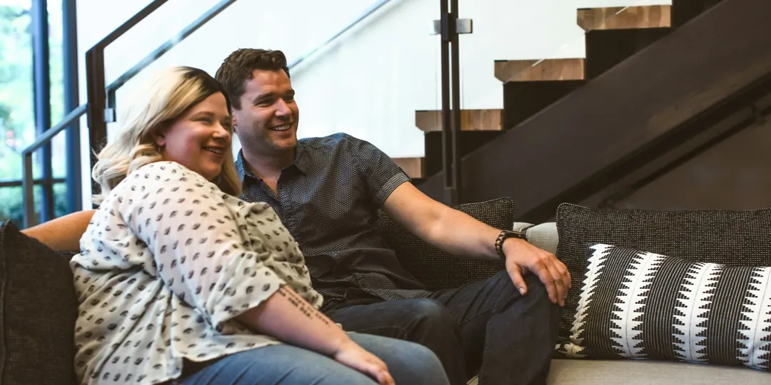 A happy couple relaxing together on the sofa at home